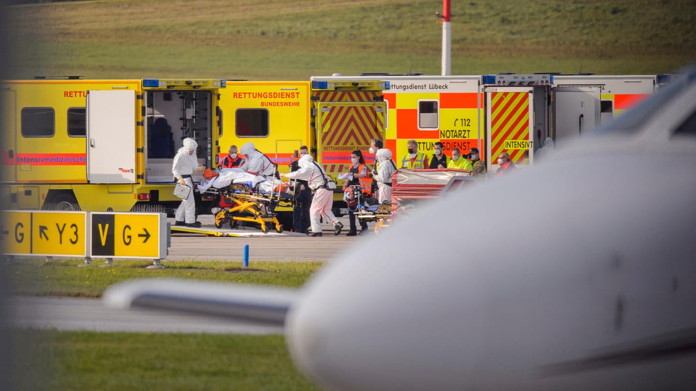 Medizinisches Personal in Schutzanzügen schiebt einen Corona-Intensivpatienten in einen Intensivmedizinischen Rettungswagen: Die Bundeswehr hat sechs schwer erkrankte Corona-Patienten aus Rumänien zur Behandlung nach Hamburg geflogen.