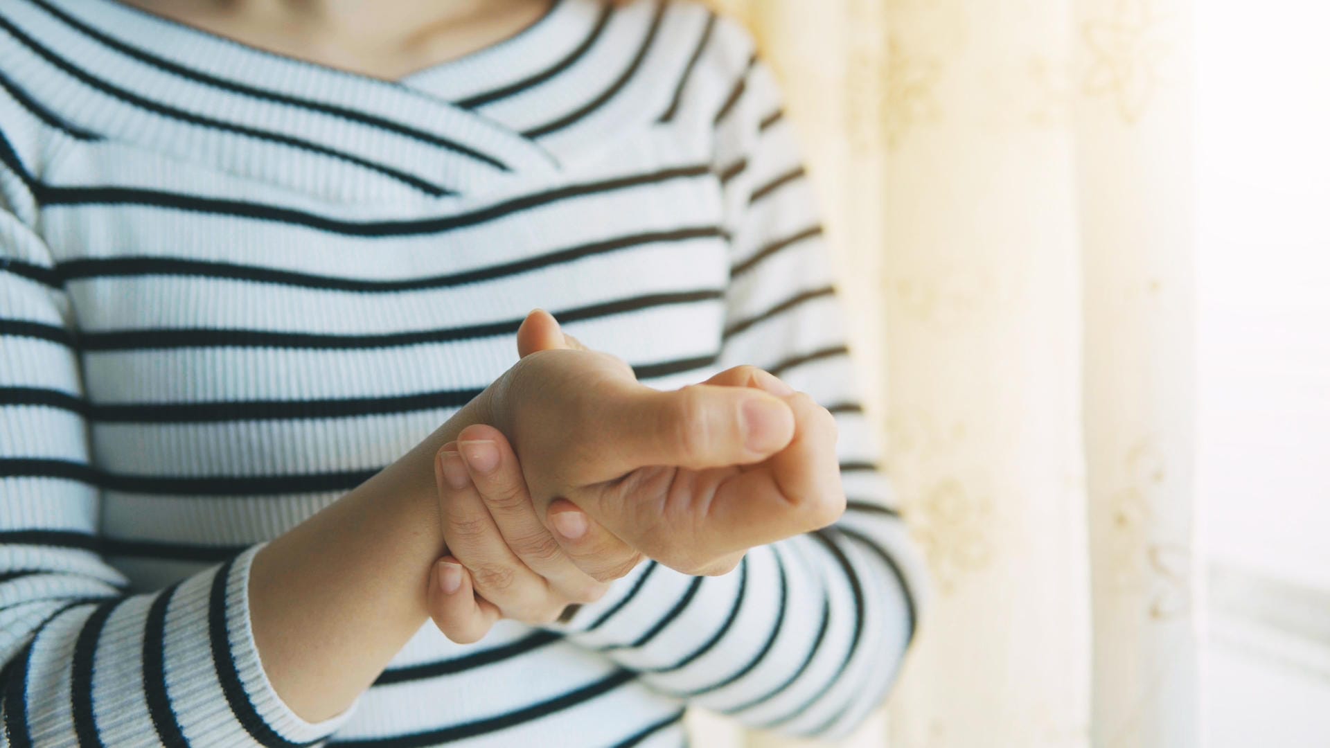 Eine Frau hat Schmerzen in der Hand: Eine Rhizarthrose kann sehr schmerzhaft sein.