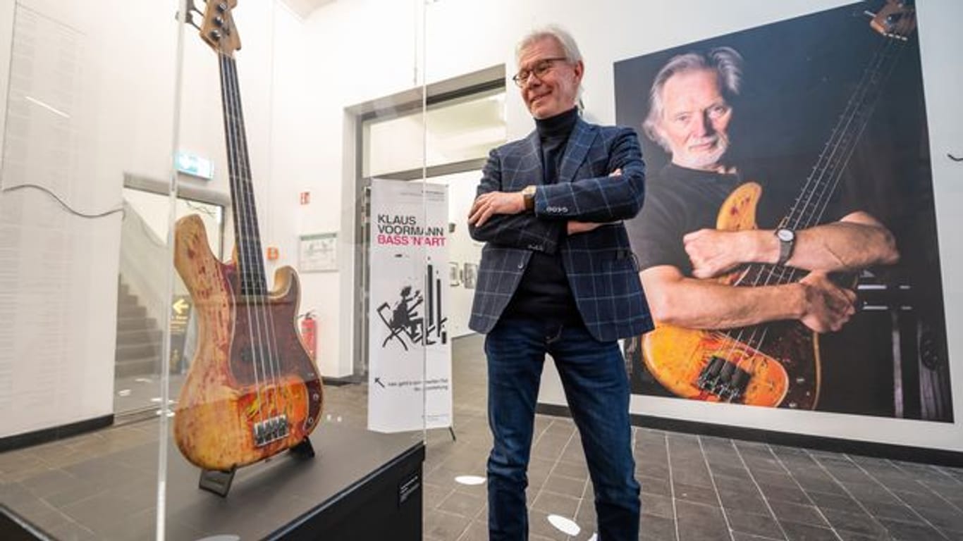 Carsten Junge, Leiter der Kunsthalle der Sparkassenstiftung Lüneburg, in der Ausstellung neben einer Bassgitarre von Klaus Voormann.