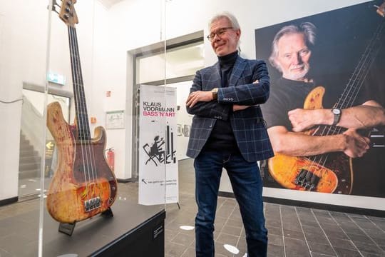 Carsten Junge, Leiter der Kunsthalle der Sparkassenstiftung Lüneburg, in der Ausstellung neben einer Bassgitarre von Klaus Voormann.