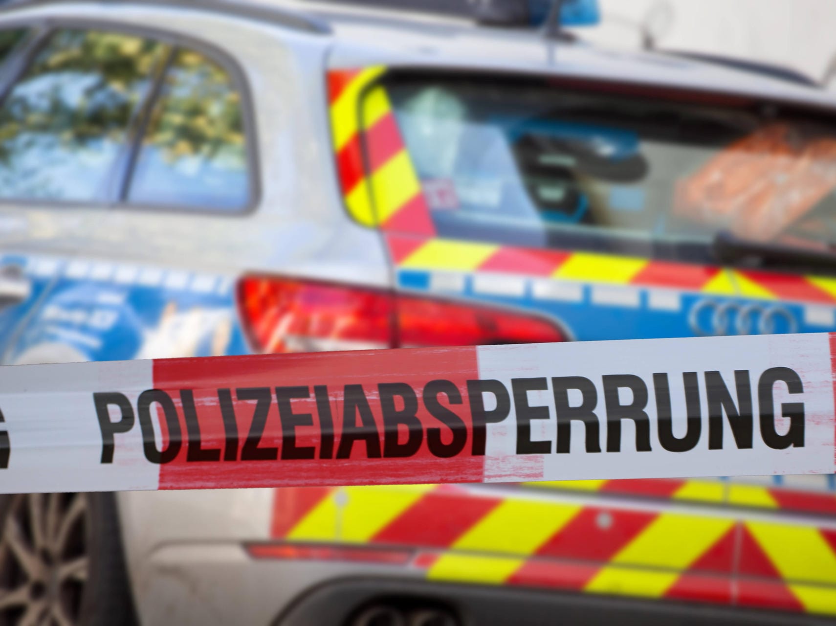 Polizeiabsperrung mit Polizeiauto im Hintergrund (Symbolbild): Mit einem Messer soll er sie ins Auto gezwungen haben.