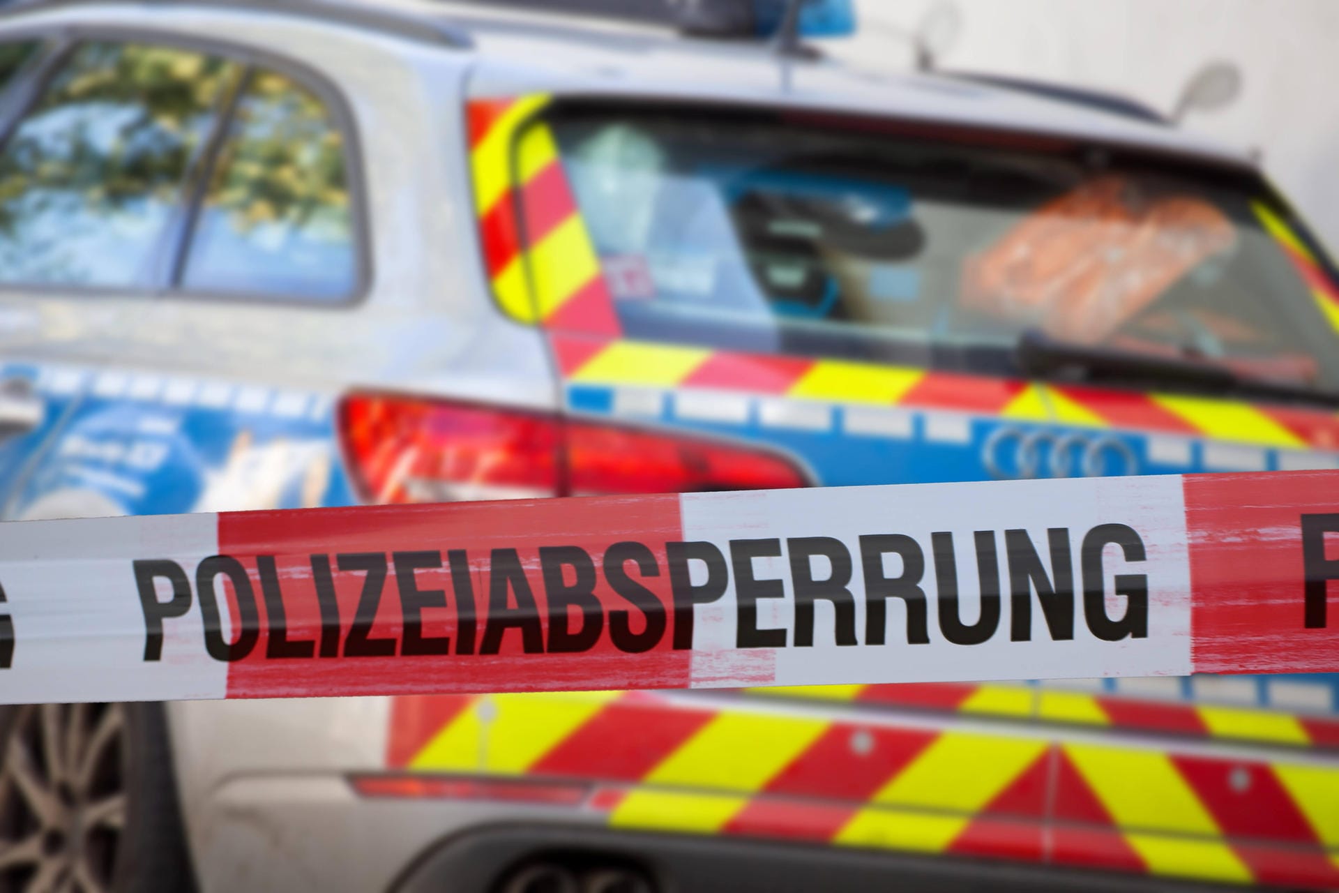 Polizeiabsperrung mit Polizeiauto im Hintergrund (Symbolbild): Mit einem Messer soll er sie ins Auto gezwungen haben.