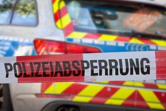 Polizeiabsperrung mit Polizeiauto im Hintergrund (Symbolbild): Mit einem Messer soll er sie ins Auto gezwungen haben.