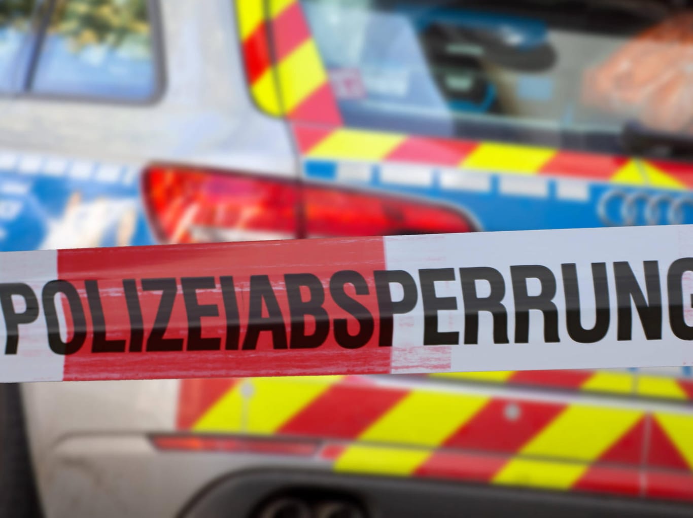 Polizeiabsperrung mit Polizeiauto im Hintergrund (Symbolbild): Mit einem Messer soll er sie ins Auto gezwungen haben.