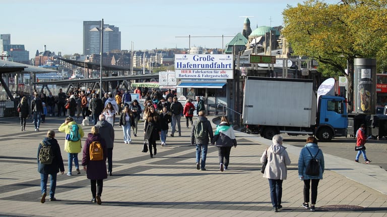 Passanten drängen sich trotz steigender Corona-Zahlen bei herbstlichem Sonnenschein auf der Hafenpromenade: In Hamburg sollen Infizierte künftig ihre Kontakte selbst nachverfolgen.