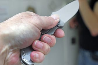 Eine Hand mit einem Messer (Symbolbild): Weil er eine Frau im Schlaf erstochen hat, wurde ein 41-jähriger zu einer lebenslangen Haftstrafe verurteilt.