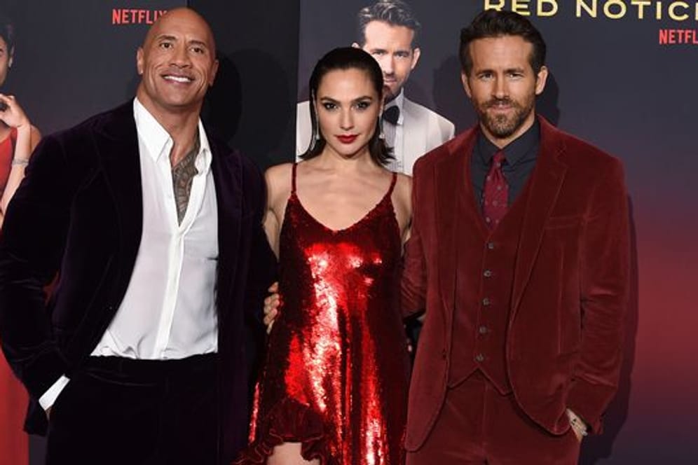 Die Darsteller Dwayne Johnson (l-r), Gal Gadot und Ryan Reynolds bei der Premiere von "Red Notice" in Los Angeles.
