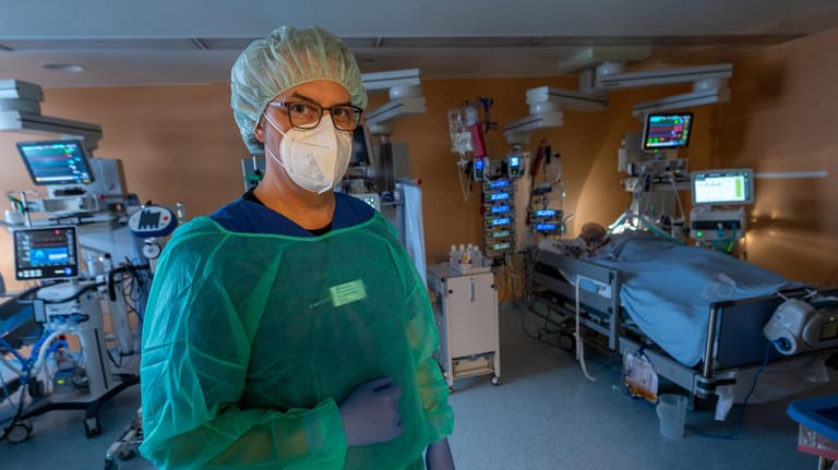 Chefarzt Lorenz Nowak steht in Schutzkleidung in einem Intensivbett-Zimmer (Symbolbild): Die Inzidenz in Deutschland steigt weiter.
