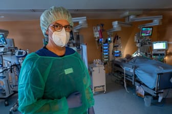 Chefarzt Lorenz Nowak steht in Schutzkleidung in einem Intensivbett-Zimmer (Symbolbild): Die Inzidenz in Deutschland steigt weiter.