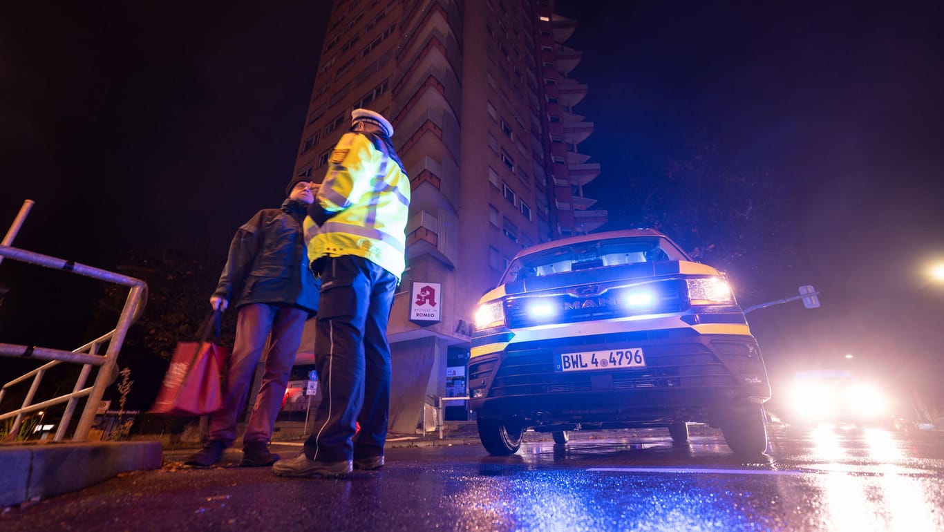 Ein Polizeibeamter im Stuttgarter Stadtteil Zuffenhausen mit einem Passanten: Der Fundort muss im Umkreis von 500 Metern evakuiert werden.