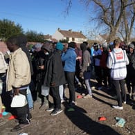 Flüchtlinge stehen in Calais für die Ausgabe von Frühstück Schlange: Aus dem Ort in Frankreich wollen viele Migranten über den Ärmelkanal nach Großbritannien übersetzen.