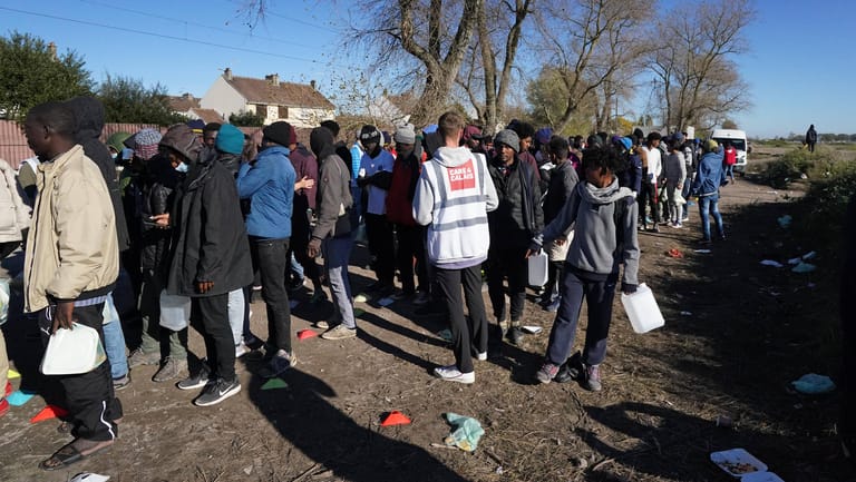 Flüchtlinge stehen in Calais für die Ausgabe von Frühstück Schlange: Aus dem Ort in Frankreich wollen viele Migranten über den Ärmelkanal nach Großbritannien übersetzen.