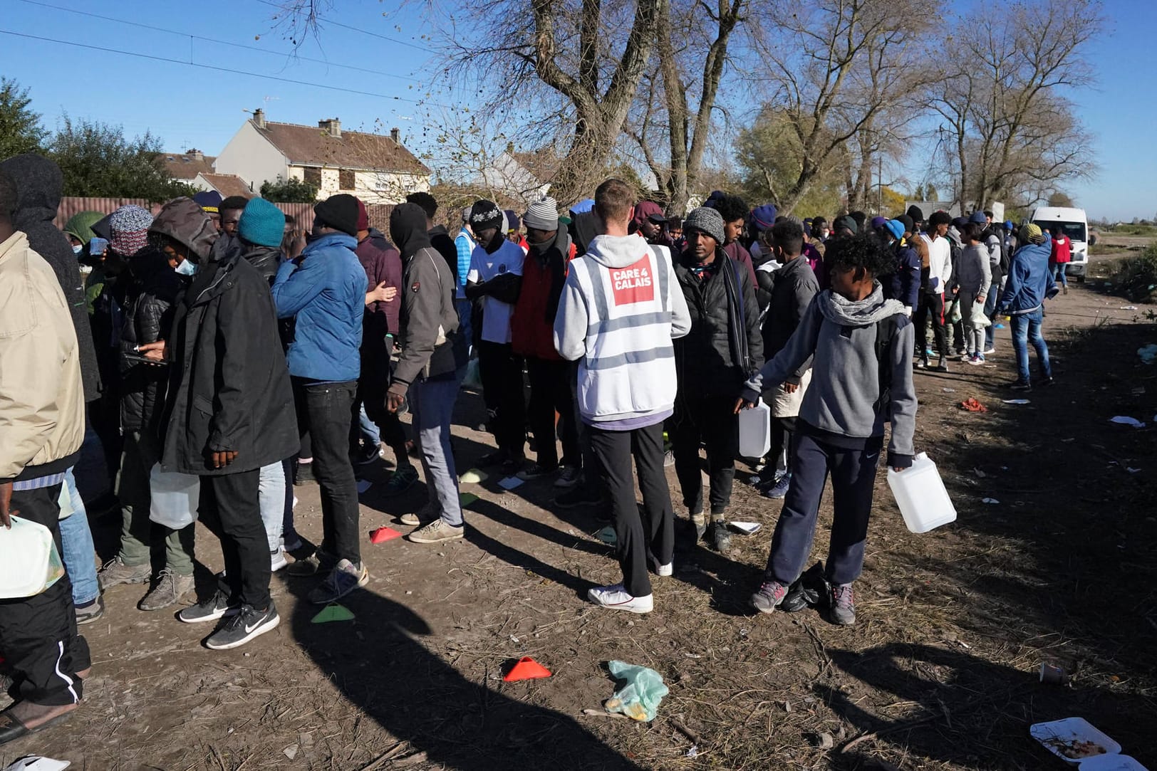 Flüchtlinge stehen in Calais für die Ausgabe von Frühstück Schlange: Aus dem Ort in Frankreich wollen viele Migranten über den Ärmelkanal nach Großbritannien übersetzen.