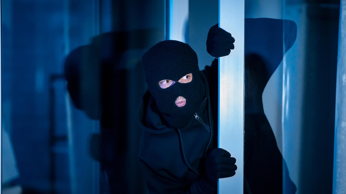 Ein Einbrecher schleicht sich durch die Tür: Wie gut wissen Sie über Einbrüche und Einbruchschutz Bescheid? Testen Sie Ihr Wissen in unserem Quiz.