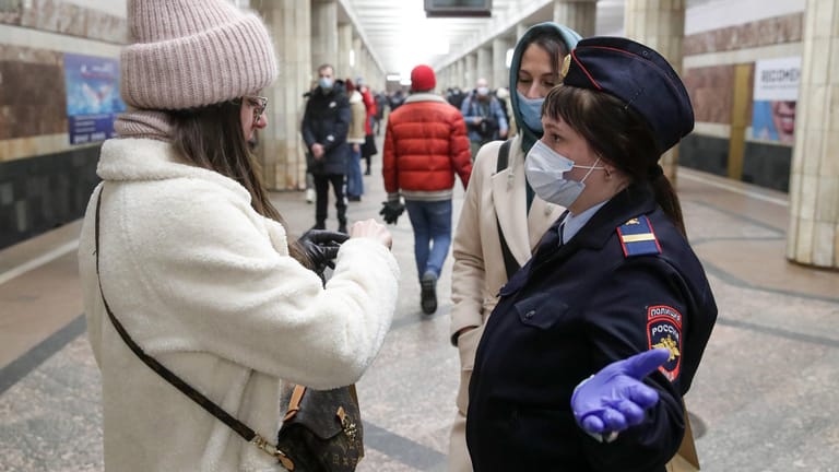 Novosibirsk: Eine Frau wird bei einer Maskenkontrolle von einer Polizistin aufgehalten.