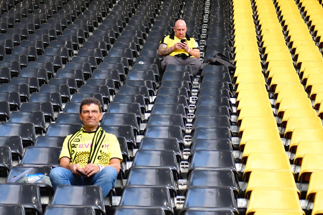 Vorfreude sieht anders aus: Zwei BVB-Fans auf der Tribüne im Signal Iduna Park.