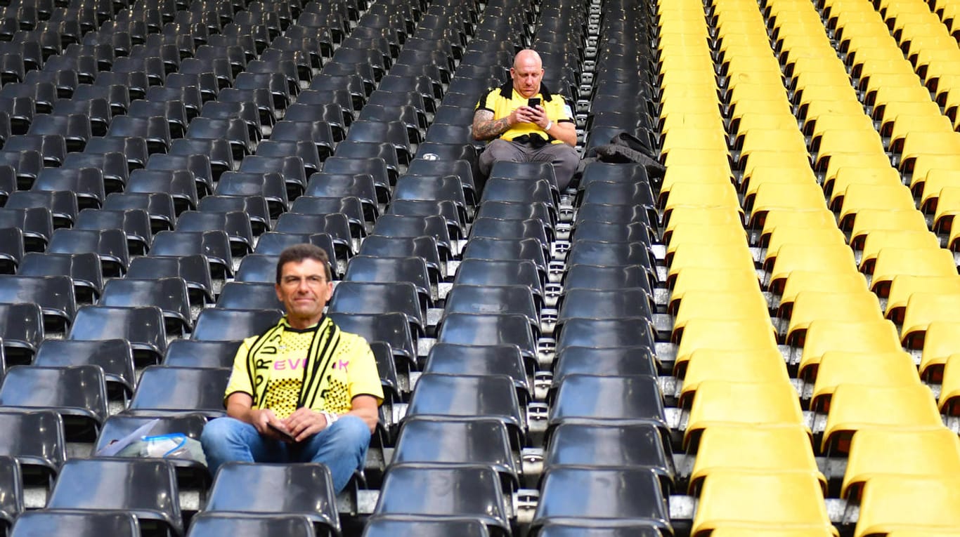 Vorfreude sieht anders aus: Zwei BVB-Fans auf der Tribüne im Signal Iduna Park.