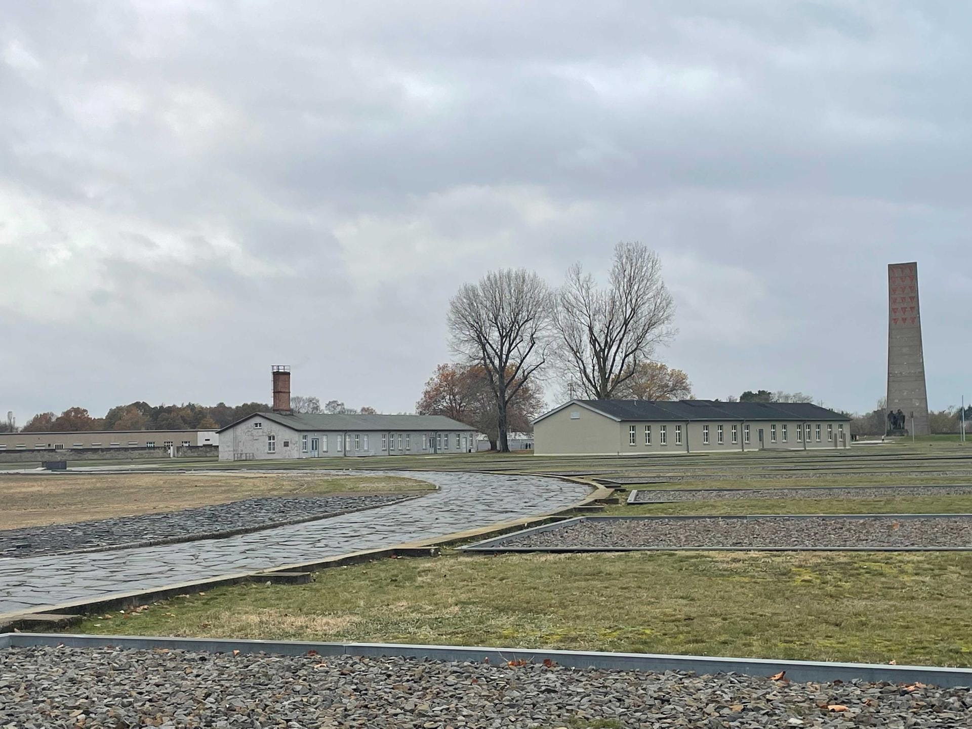 Blick auf zwei Baracken und den Obelisken: Viele Häftlings-Baracken wurden nach dem Krieg zerstört.
