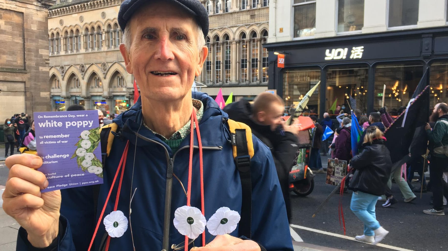 Douglas verteilt Anstecker der Friedensbewegung an die Aktivisten: Ihm ist wichtig, dass sich verschiedene gesellschaftliche Bewegungen gegenseitig unterstützen.