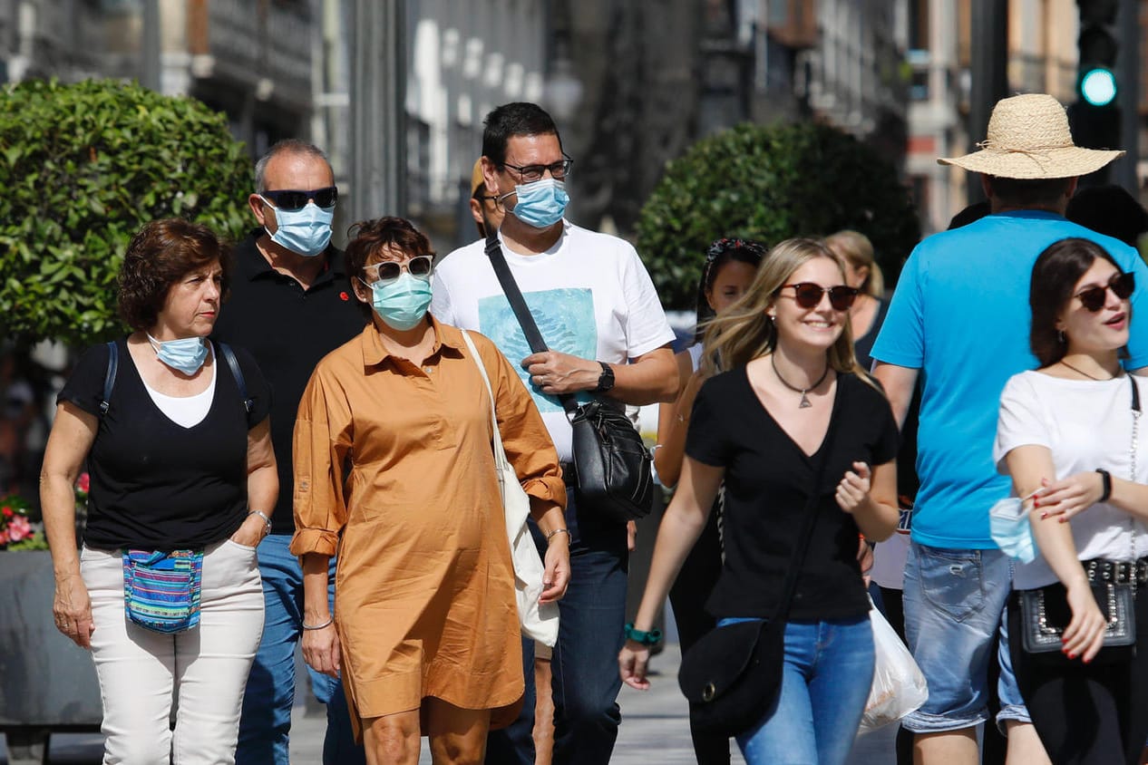Menschen mit Maske und ohne: Der Druck auf Ungeimpfte steigt.
