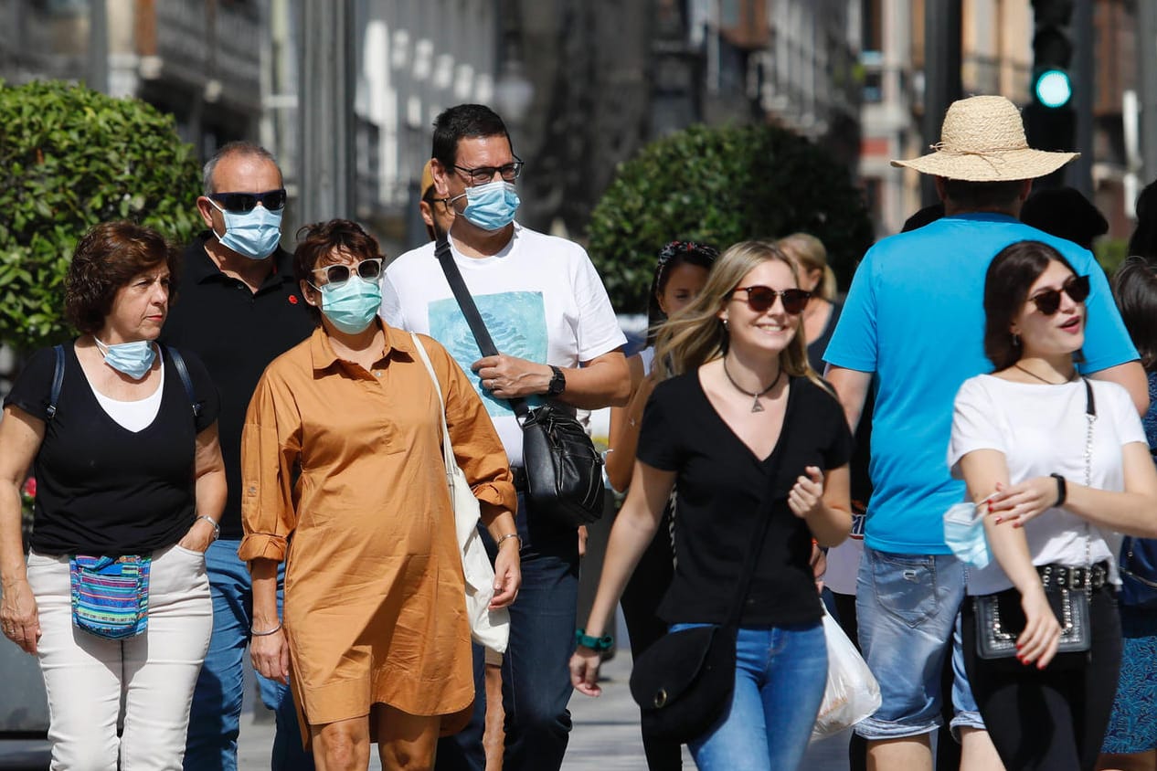 Menschen mit Maske und ohne: Der Druck auf Ungeimpfte steigt.