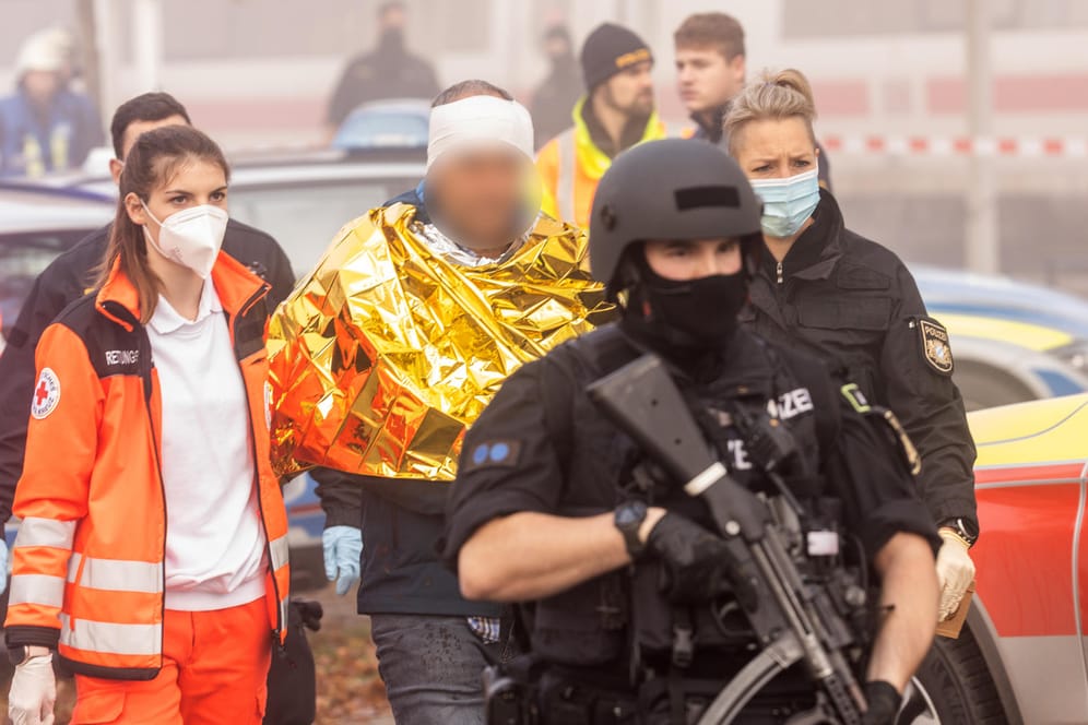 Bayern, Seubersdorf: Der Festgenommene wird am Bahnhof von Polizei und Rettungskräften abgeführt.