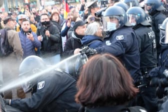 Ein Polizist setzt Pfefferspray gegen Teilnehmer der Corona-Leugner-Demo ein: Am Nachmittag ist es zu Ausschreitungen in Leipzig gekommen.