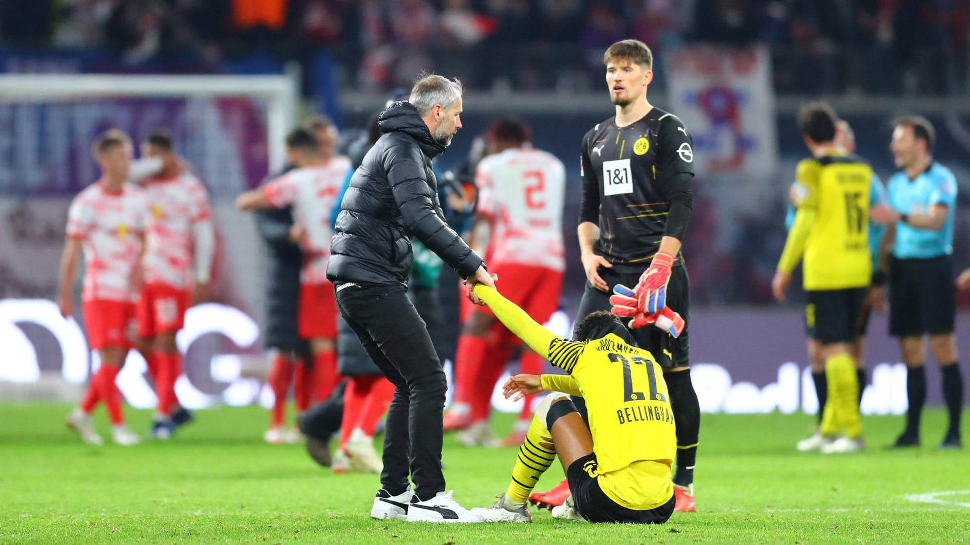 Hilft seinem enttäuschten Youngster Jude Bellingham beim Aufstehen: BVB-Coach Marco Rose (l.).