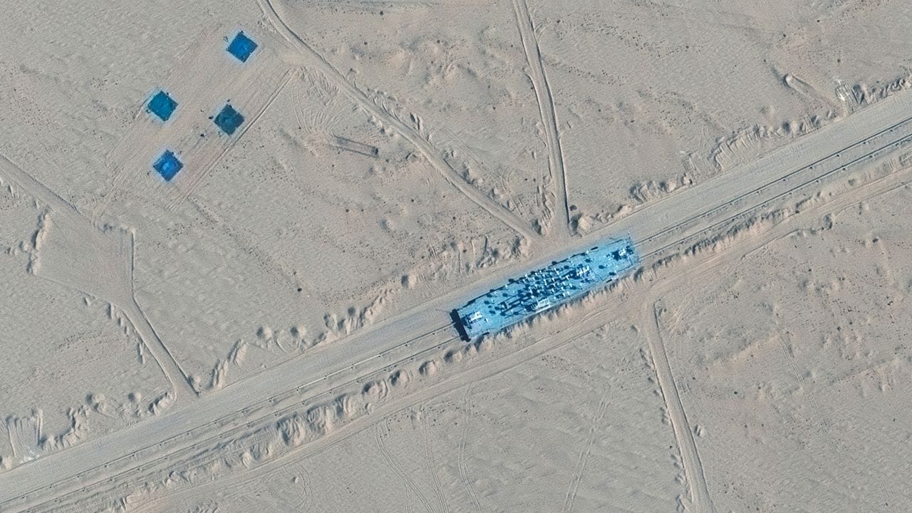 Das Satellitenbild zeigt ein Gebäude auf Bahngleisen in der Ruoqiang-Gegend der Taklamakan-Wüste.