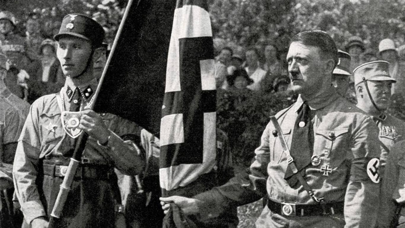 Adolf Hitler mit der berüchtigten "Blutfahne": Im November 1923 wollte der "Führer" bereits die Demokratie stürzen.
