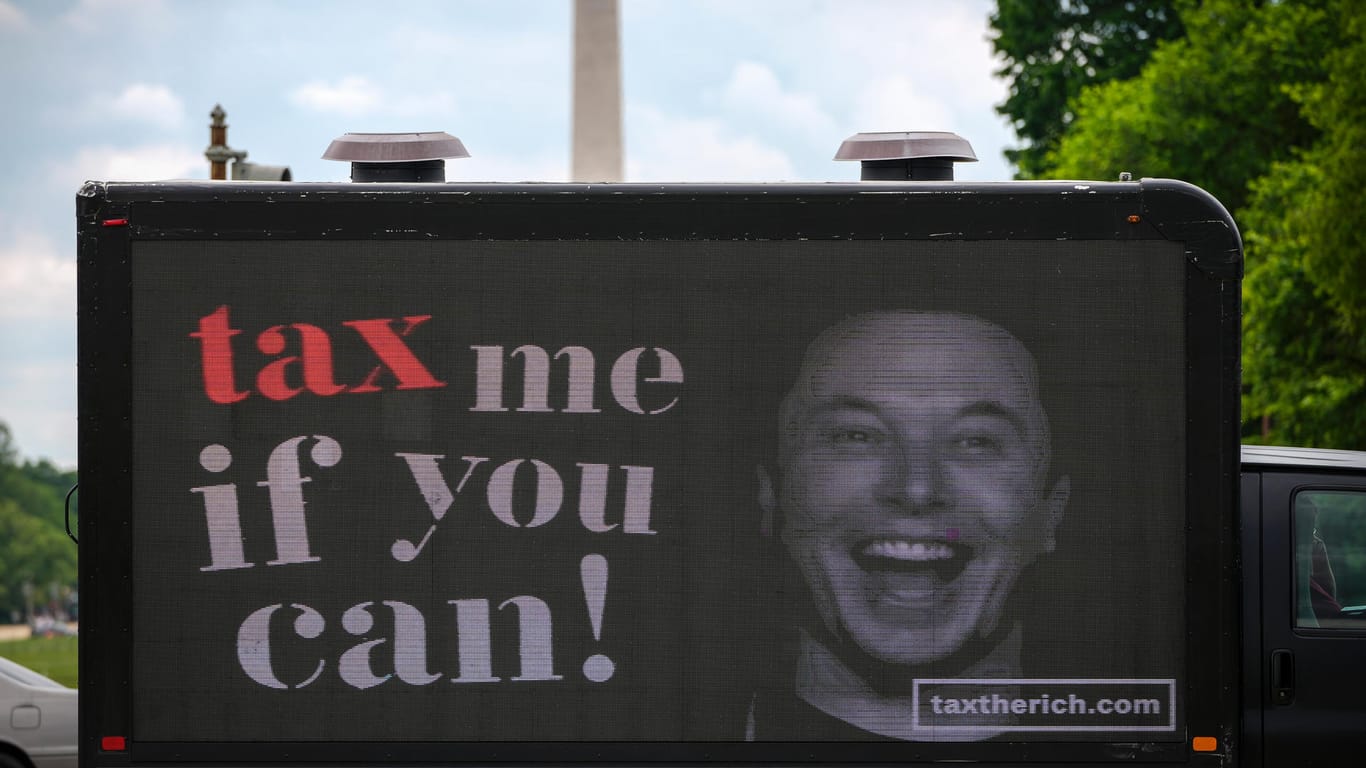 Protest gegen Musk: Der Superreiche soll laut Kritikern zu wenig Steuern zahlen. Ausgerechnet eine hohe Steuerzahlung könnte ihm nun zum Verkauf eines großen Aktienpakets verleiten.