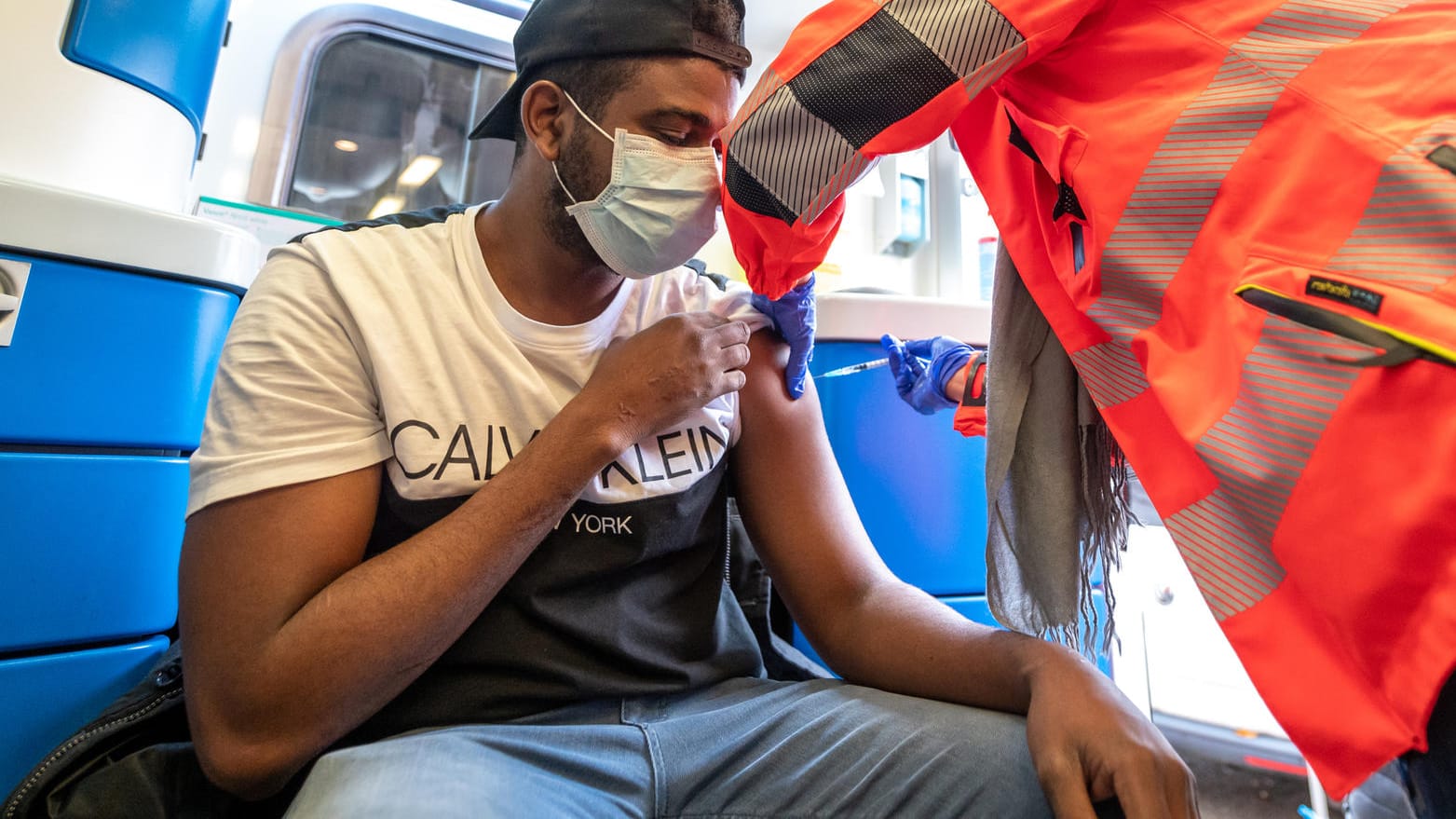 Ein Mann lässt sich in einem Krankenwagen gegen Corona impfen: Die große Zahl der Ungeimpften lässt die Diskussion über eine Impfplicht wieder aufflammen.