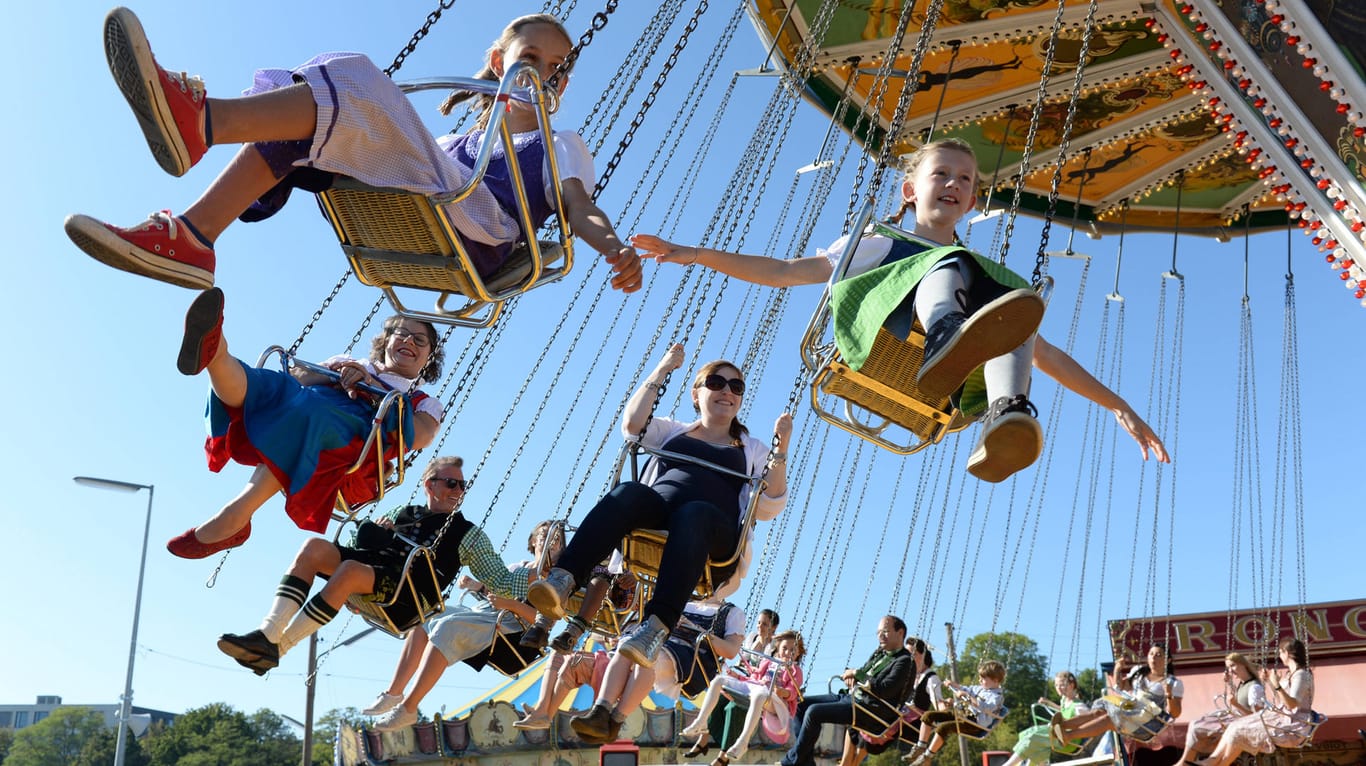 Kinder fahren Karussell auf dem Oktoberfest "Oide Wiesn" (Archivbild): Die Ticketpreise für das beliebte Fest könnten sich erhöhen.