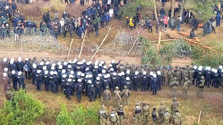 Dutzende Migranten haben den provisorischen Zaun mit Baumstämmen niedergerissen, polnische Polizisten und Soldaten hindern sie am Grenzübertritt.