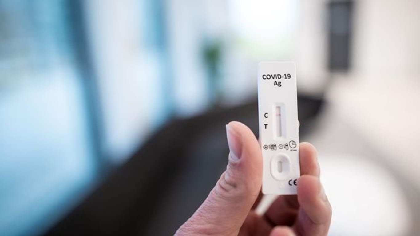 Eine Hand hält einen Corona-Schnelltest (Symbolbild): Ungeimpfte Pflegekräfte in Alten- und Pflegeheimen müssen sich täglich auf das Coronavirus testen lassen.