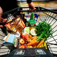 Einkaufswagen in einem Supermarkt (Symbolbild): Unternehmen könnten höhere Herstellungskosten auf die Kunden abwälzen.