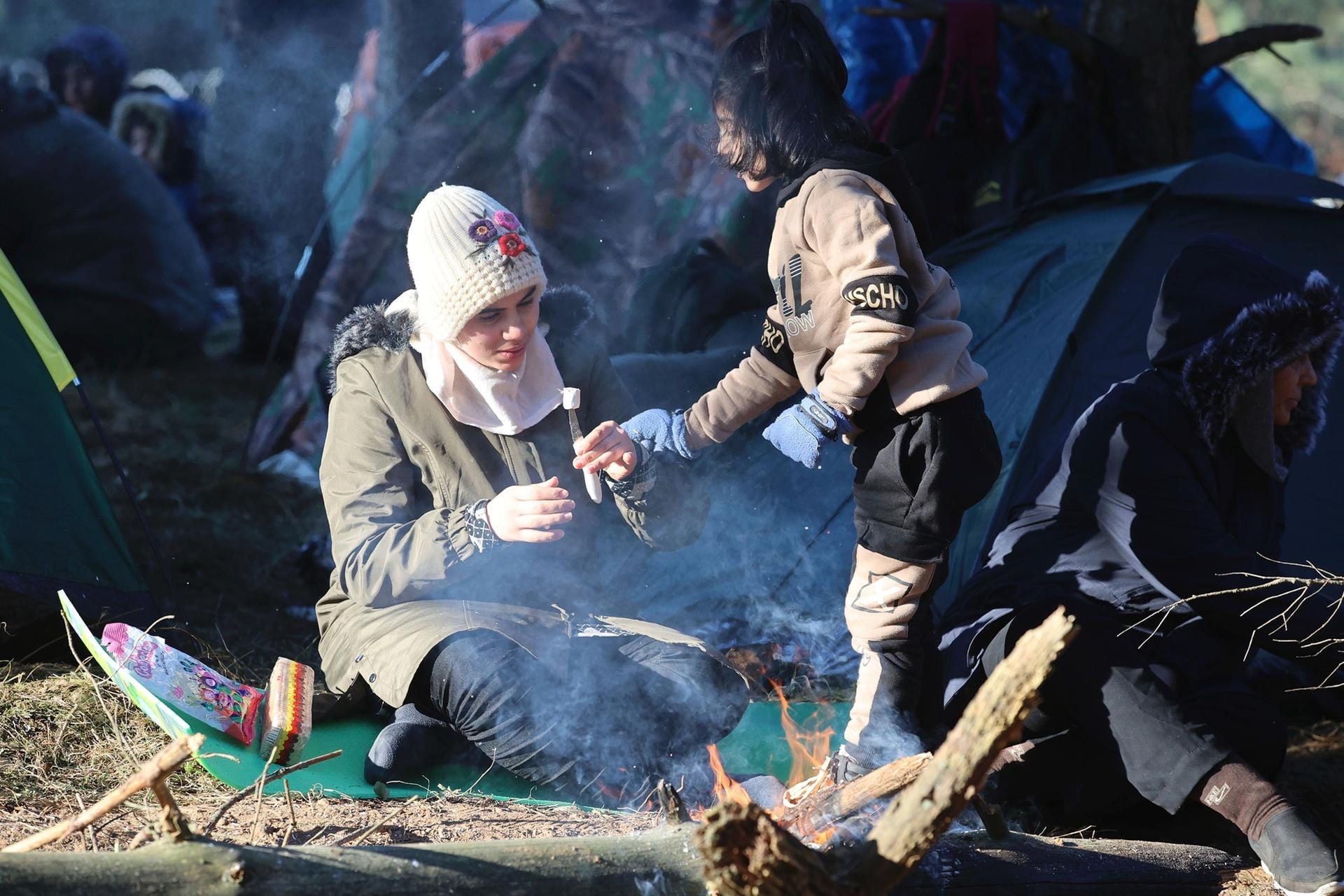 Eine Frau und ihr Kind essen, während sie sich mit anderen Migranten an der belarussisch-polnischen Grenze versammeln: An der EU-Außengrenze spitzt sich die Situation weiter zu.