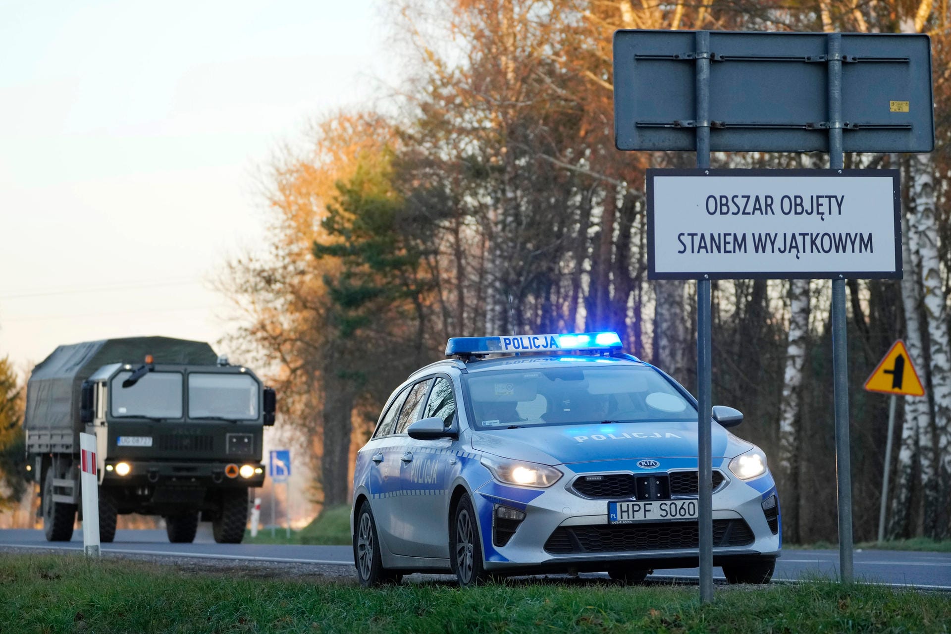Ein polnischer Polizeiwagen und ein Militärlastwagen stehen an einem behelfsmäßigen Kontrollpunkt in Polen: Zwei größere Gruppen von Flüchtlingen haben auf ihrem erhofften Weg in die EU einem polnischen Medienbericht zufolge die Grenze von Belarus nach Polen durchbrochen.