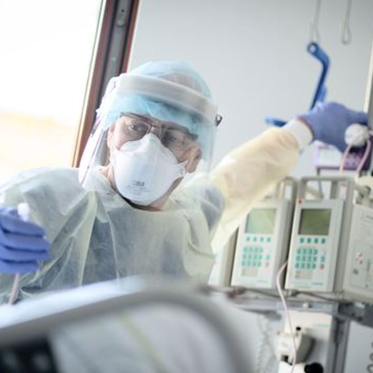 Ein Intensivpfleger arbeitet auf der Intensivstation eines Krankenhauses (Symbolbild): Operationen könnten abgesagt werden, weil das Personal für die Pflege von Covid-Patienten benötigt wird.