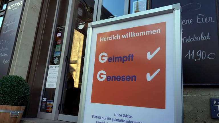 Ein Schild in Chemnitz weist auf die 2G-Regel hin: Der Wirtschaftsweise Volker Wieland hält eine bundesweite Ausweitung der Regel für sinnvoll.