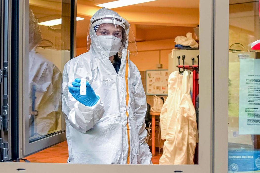 Die Mitarbeiterin einer Teststation zeigt ein Ergebnis: Die kostenlosen Tests könnte es bereits ab nächster Woche wieder geben.