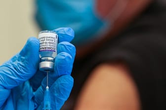 Eine Spritze wird mit dem Biontech/Pfizer-Impfstoff aufgezogen (Symbolbild): Die gemeldeten Infektionen in Deutschland nehmen weiter zu.