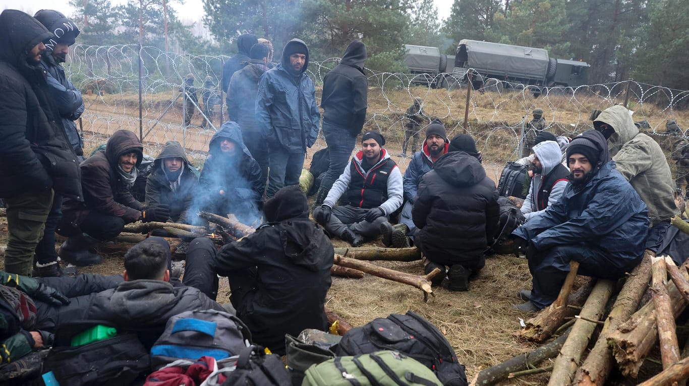 Belarus, Grodno: Migranten versammeln sich an der belarussisch-polnischen Grenze um ein Feuer. Es herrschen Minusgrade.