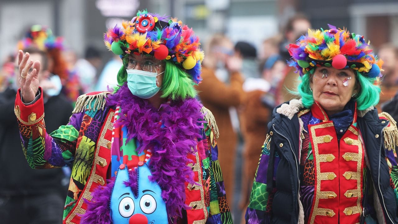 Karnevalistinnen in Köln: eine mit Maske, eine ohne.