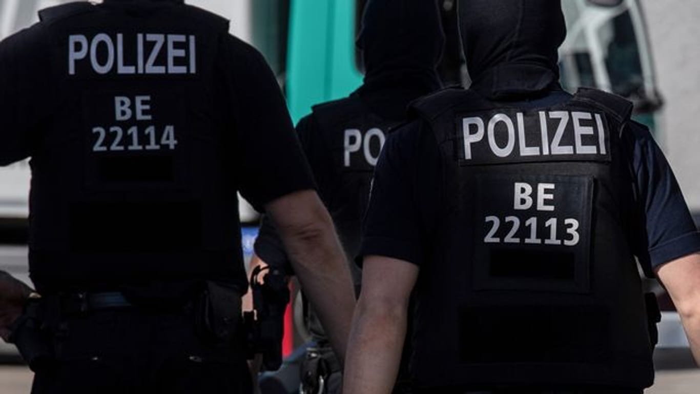 Berliner Polizisten gehen über eine Straße (Symbolbild): Das Filmen und Aufnehmen von Polizeieinsätzen ist rechtlich umstritten.