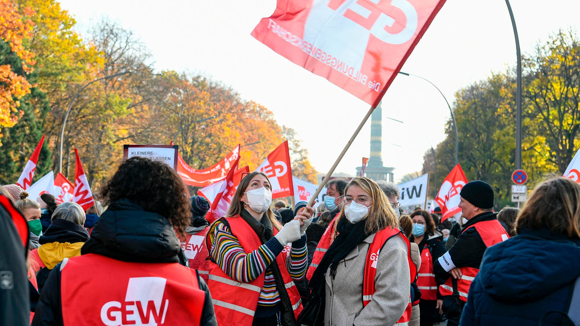 Teilnehmer der Demo der Gewerkschaft Erziehung und Wissenschaft (GEW) stehen in Berlin-Tiergarten und schwenken eine Fahne: Sie fordern mehr Gehalt. Teilnehmer der Demo der Gewerkschaft Erziehung und Wissenschaft (GEW) stehen in Berlin-Tiergarten und schwenken eine Fahne: Sie fordern mehr Gehalt.