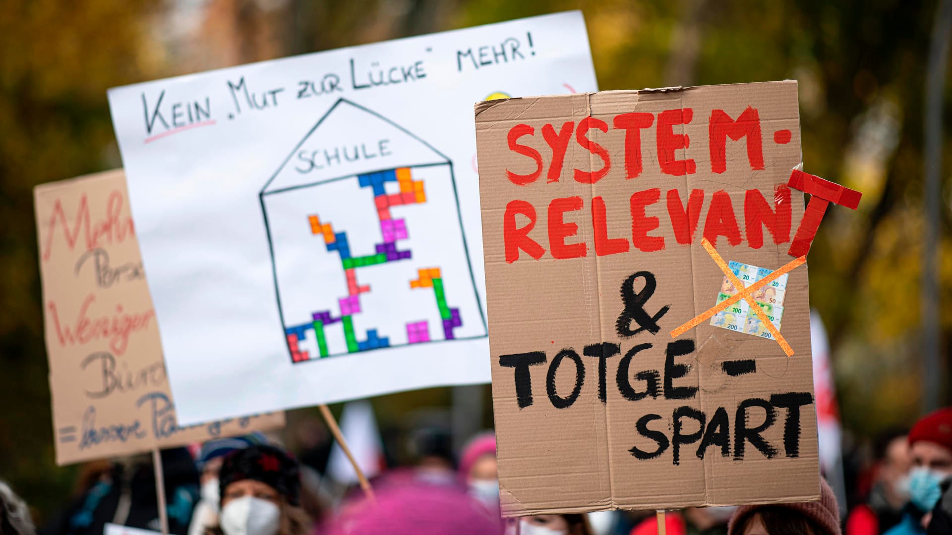Ein Demonstrierender hält ein Schild mit der Aufschrift "Systemrelevant und totgespart": Tausende Beschäftigte sind in Berlin in den Warnstreik getreten.