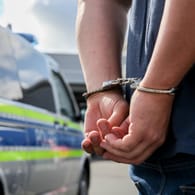 Person trägt Handschellen (Symbolbild): Die drei Männer wurden wegen Mordverdachts festgenommen.