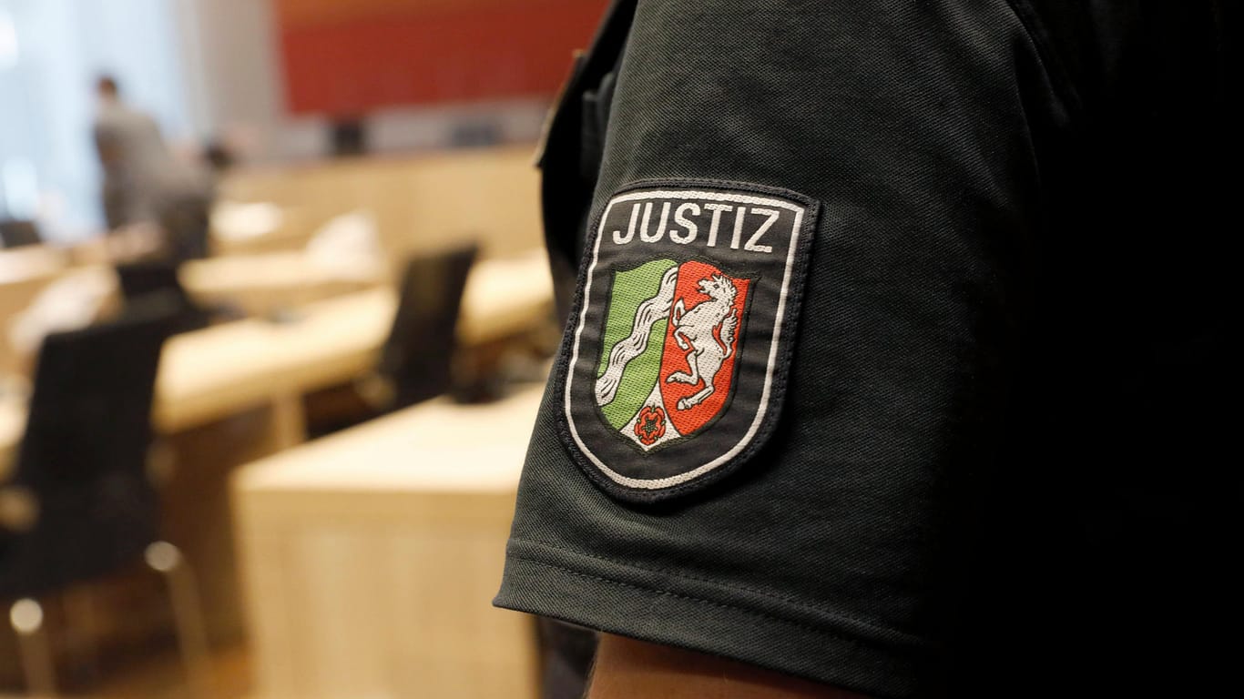Ein Justizmitarbeiter steht im Gerichtssaal (Symbolbild): Vor dem Kölner Landgericht sitzt ein 19-Jähriger wegen Mordversuchs auf der Anklagebank.