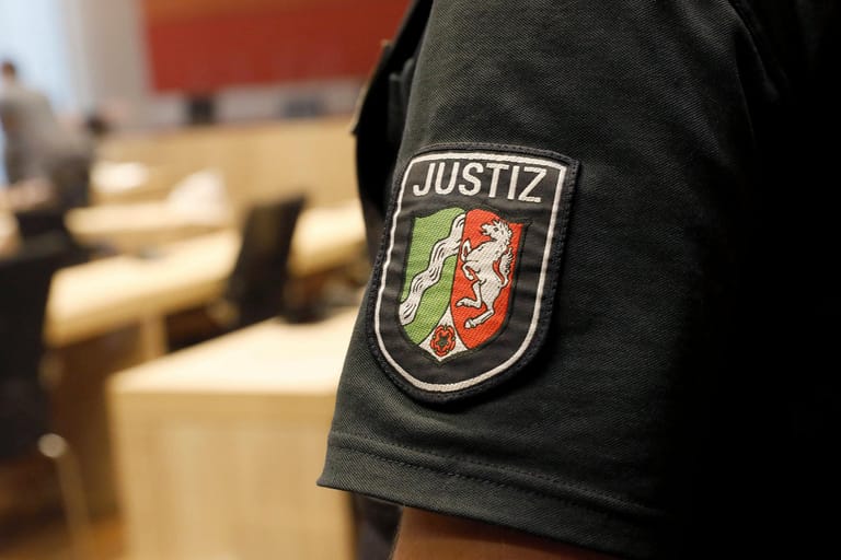 Ein Justizmitarbeiter steht im Gerichtssaal (Symbolbild): Vor dem Kölner Landgericht sitzt ein 19-Jähriger wegen Mordversuchs auf der Anklagebank.